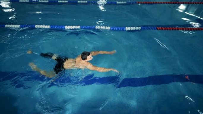 带有假肢的运动员在游泳池中游泳，俯视图。