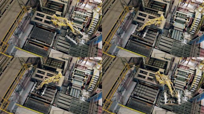 机械臂在俯视图中移动砖块。工业工厂工作的自动机械臂。