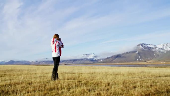 WS女摄影师用相机拍摄冰岛阳光明媚的山景