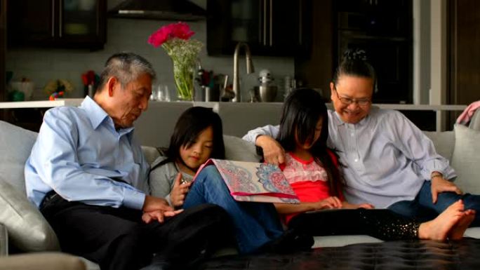 在舒适的家庭4k中使用数字平板电脑的多代亚洲家庭的前视图