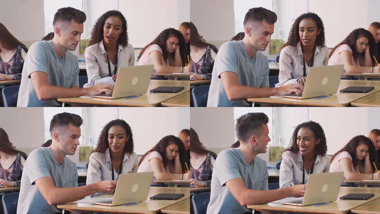女导师为在笔记本电脑上工作的男生提供一对一的支持