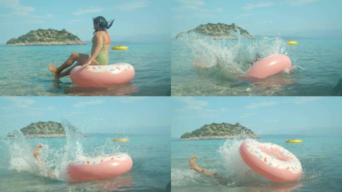超级慢动作顽皮的少女在克罗地亚佩列萨克阳光明媚的海洋中跳过充气戒指