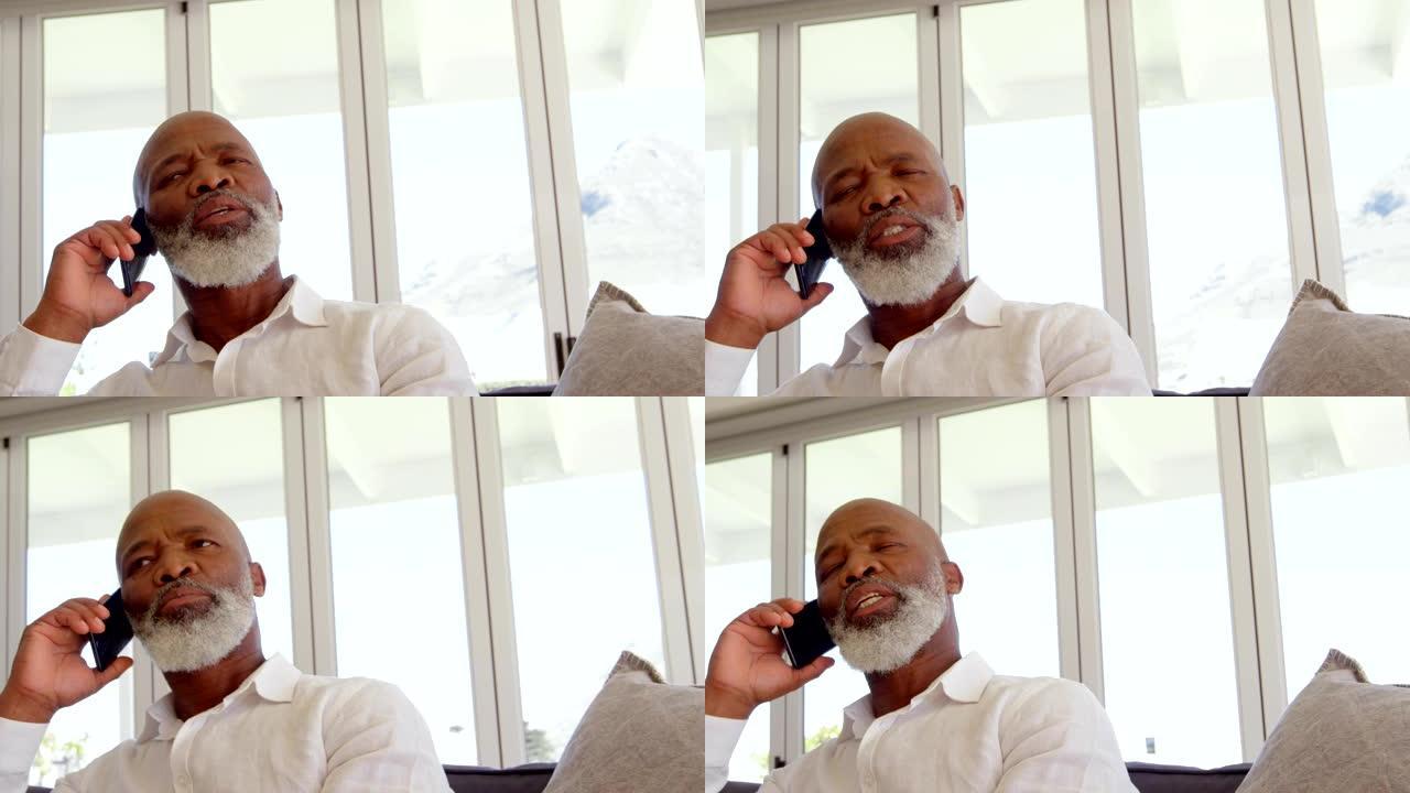 在舒适的家庭中，成熟的黑人男子在手机上聊天的前视图4k