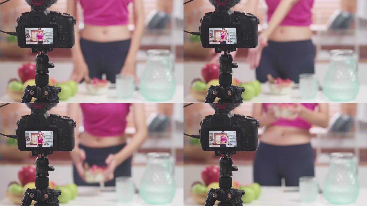 亚洲博主女人制作vlog如何节食和减肥，年轻女性在厨房吃酸奶时使用相机录音。生活方式影响者女性健康理