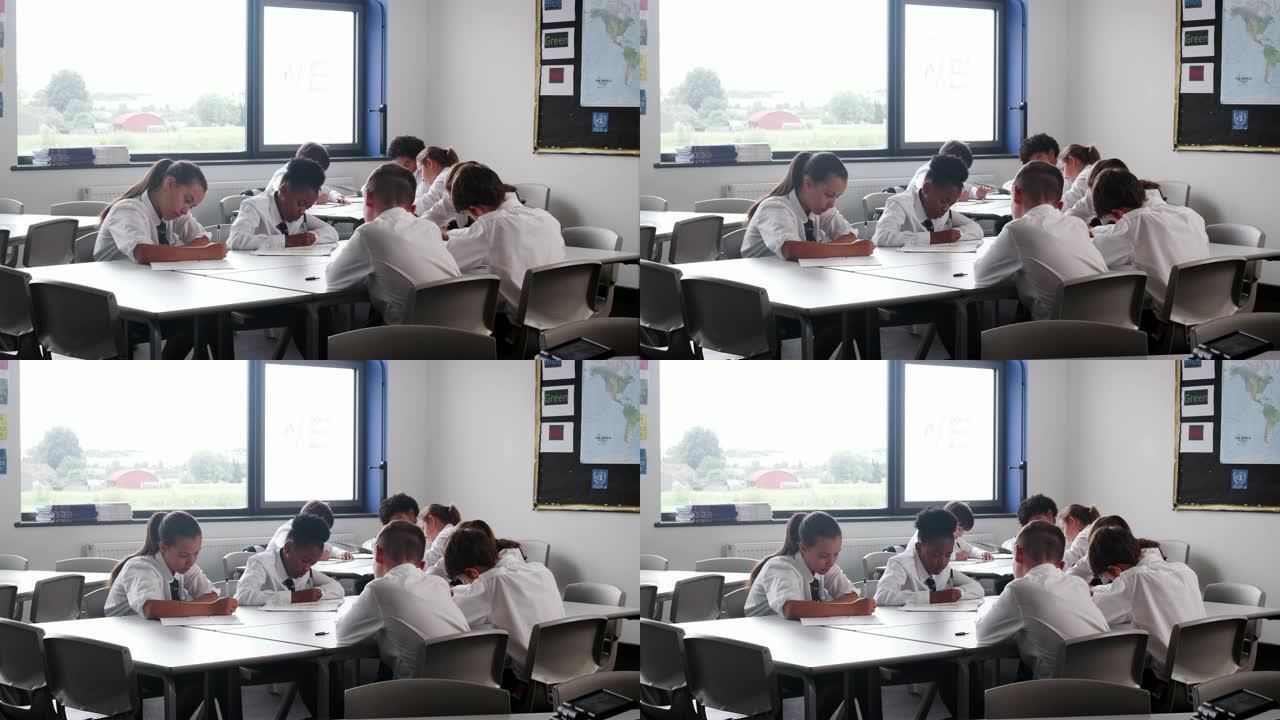 一群穿着制服在教室课桌前工作的高中生