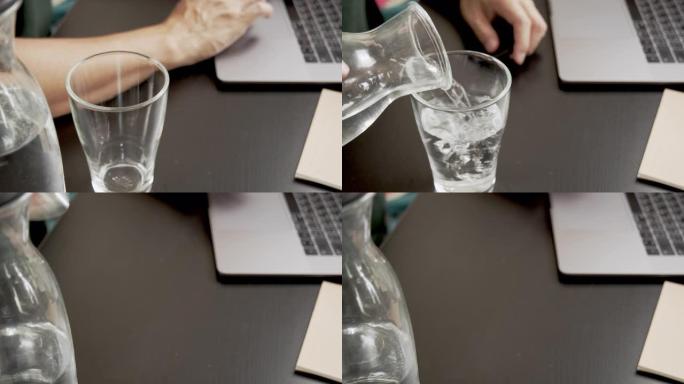 亚洲男子通过在笔记本电脑上键入业务订单在工作时倒水和喝水