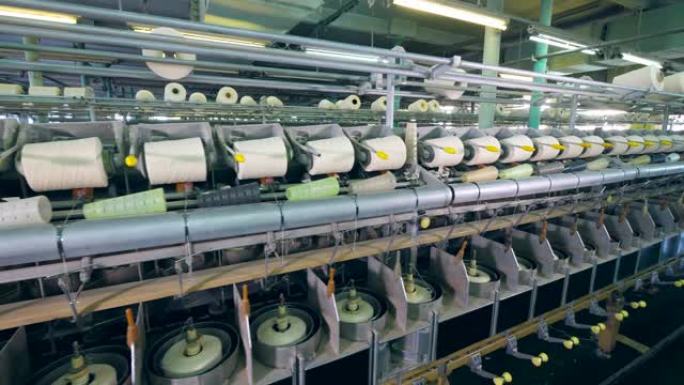 纺纱机在纺织厂工作，在线轴上缠绕线。