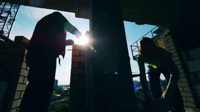 两名工程师在高层建筑中进行的砖石工程