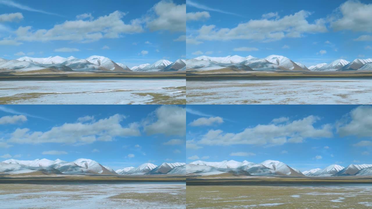 乘坐火车时，西藏积雪覆盖的平原和山脉的壮丽景色
