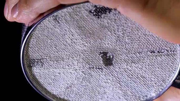 通过筛子筛分面粉的慢动作镜头。特写。