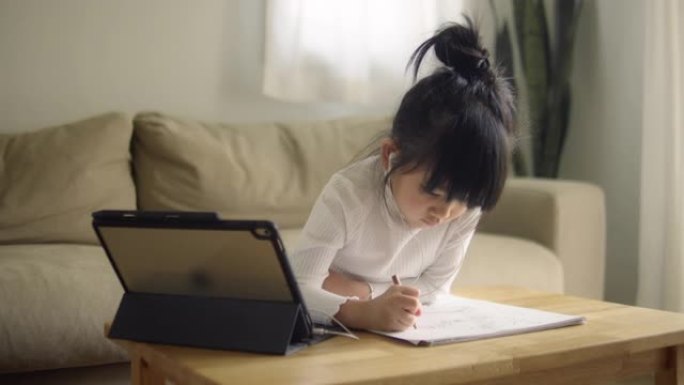 亚洲小女孩戴着耳机会议通过网络摄像头通话
