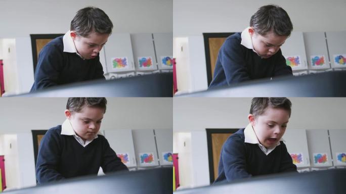 患有唐氏综合症的小学生站在教室的桌子上玩耍，低角度