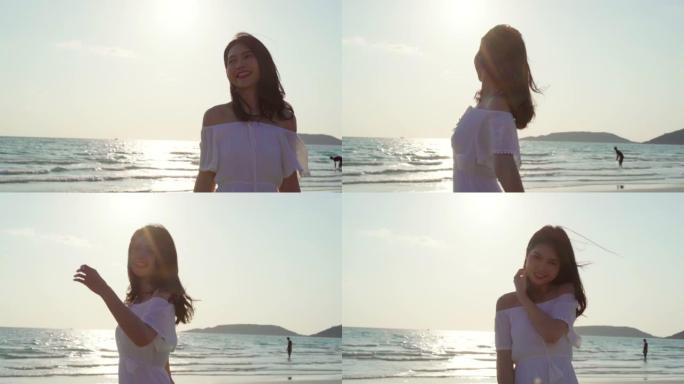 慢动作 -- 年轻的亚洲女人在海滩上散步。晚上日落时，美丽的女性快乐放松在海边的海滩上散步。生活方式