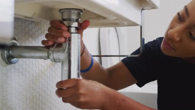 致力于修复家庭浴室中漏水的水槽的女水管工