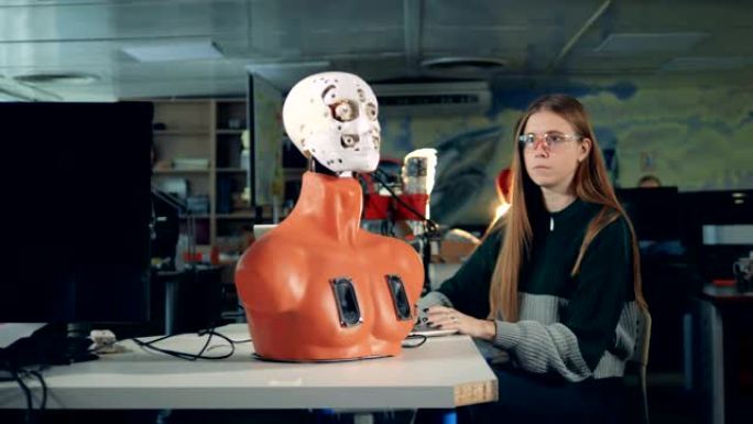 女孩正在用电脑操纵机器人的脸