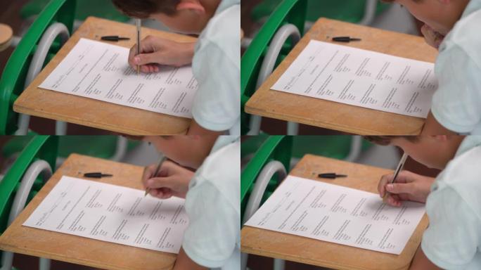 小男孩在课堂上回答多项选择考试的特写镜头
