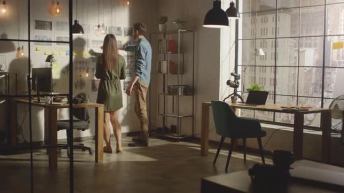 年轻的有创造力的男性和女性正在他们凉爽的办公室阁楼的墙上组织一个情绪板。图片代表未来的运动视频。同事