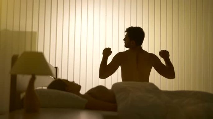 男人在床上的女人附近锻炼