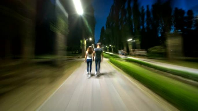 这对夫妇在夜公园散步。过度下垂