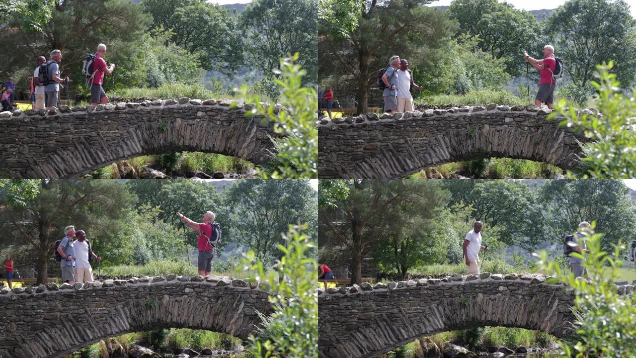 三名高年级男子在过桥时拍照。