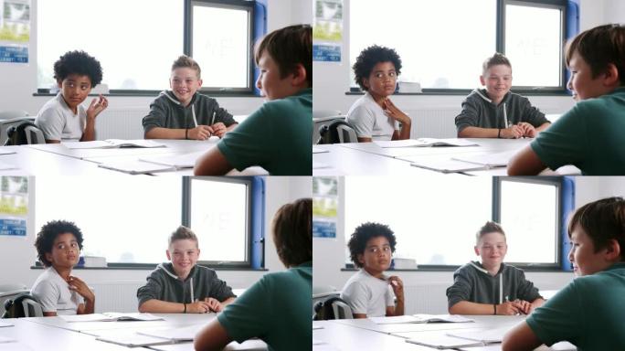 上课期间，三名男性高中生围坐在教室的桌子旁