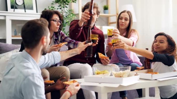 男人和女人在公寓的聚会上吃披萨烤和喝啤酒