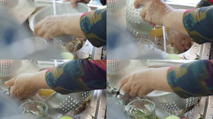 亚洲妇女洗手和清洗虾准备烹饪食物。