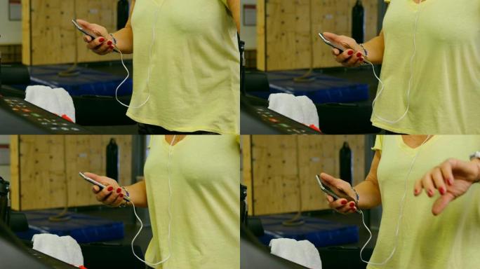健身工作室4k运动时使用手机的老年女性