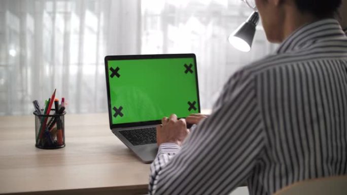 在家里的桌子上使用色度键屏幕笔记本电脑的特写镜头