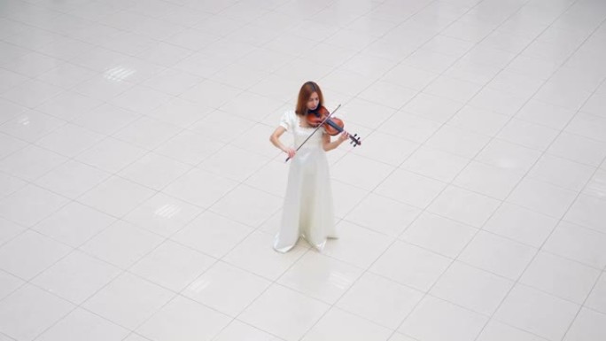 穿着白色连衣裙的女士站在白色瓷砖上拉小提琴