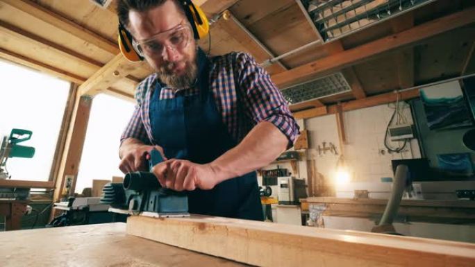 男性木匠在使用木材时使用工具。木匠在工作。