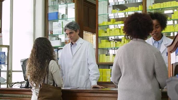 化学家在药房与女性顾客交谈