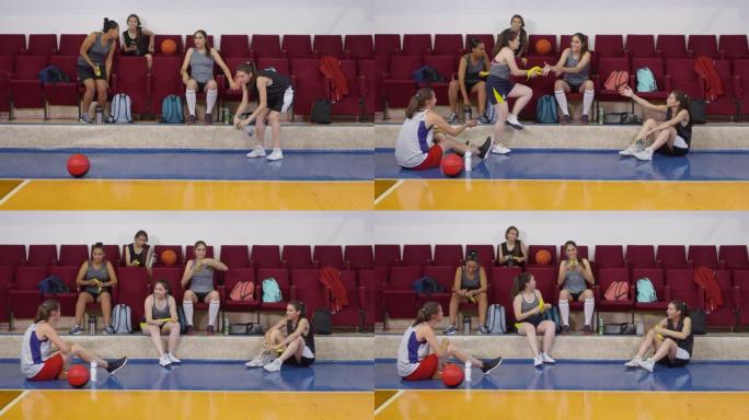 年轻女子篮球运动员训练后在球场上休息