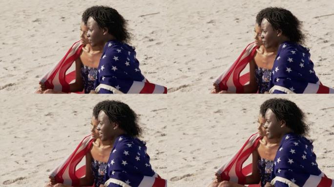 包裹着美国国旗的夫妇一起坐在海滩上4k