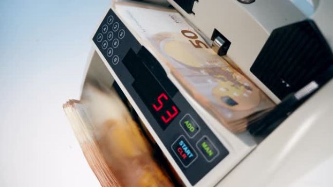 一个人用点钞机检查欧元纸币。