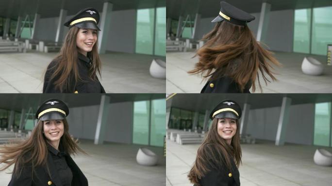 欢快的女人在机场背景前穿着飞行员服装跳舞