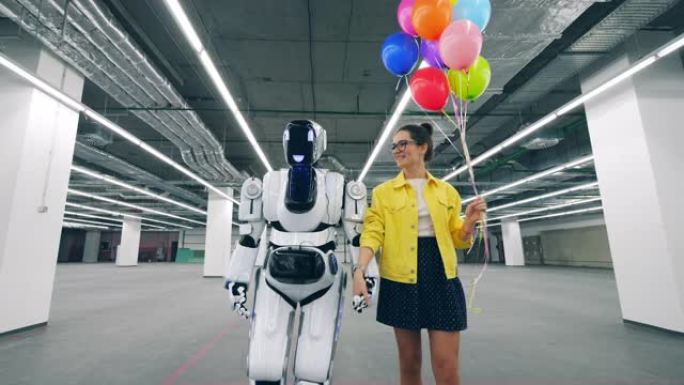 一位女士和一个机器人一起沿着大厅散步
