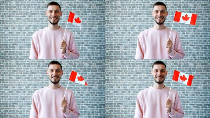 砖墙背景上手持加拿大国旗的开朗学生肖像