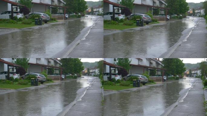 慢动作: 雨水覆盖了经过郊区梯田房屋的道路