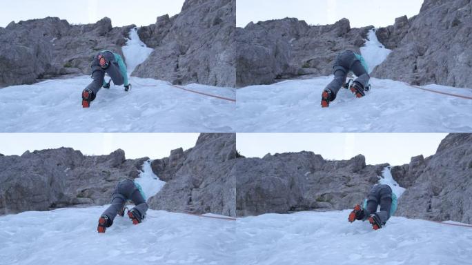 慢动作，自下而上: 女攀冰者将冰爪踢进坚硬的冰中。
