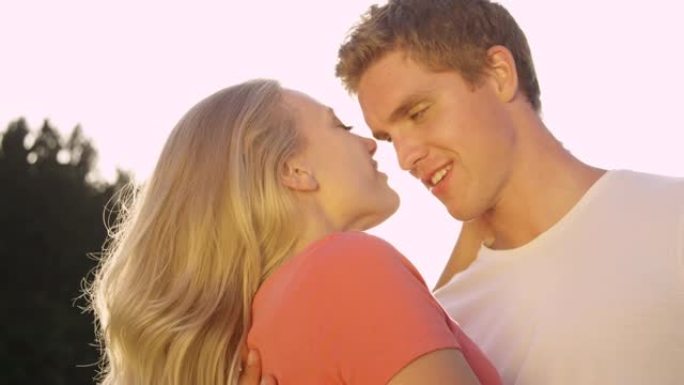 镜头耀斑: 快乐的男人和女人在夏日的额头上互相亲吻。