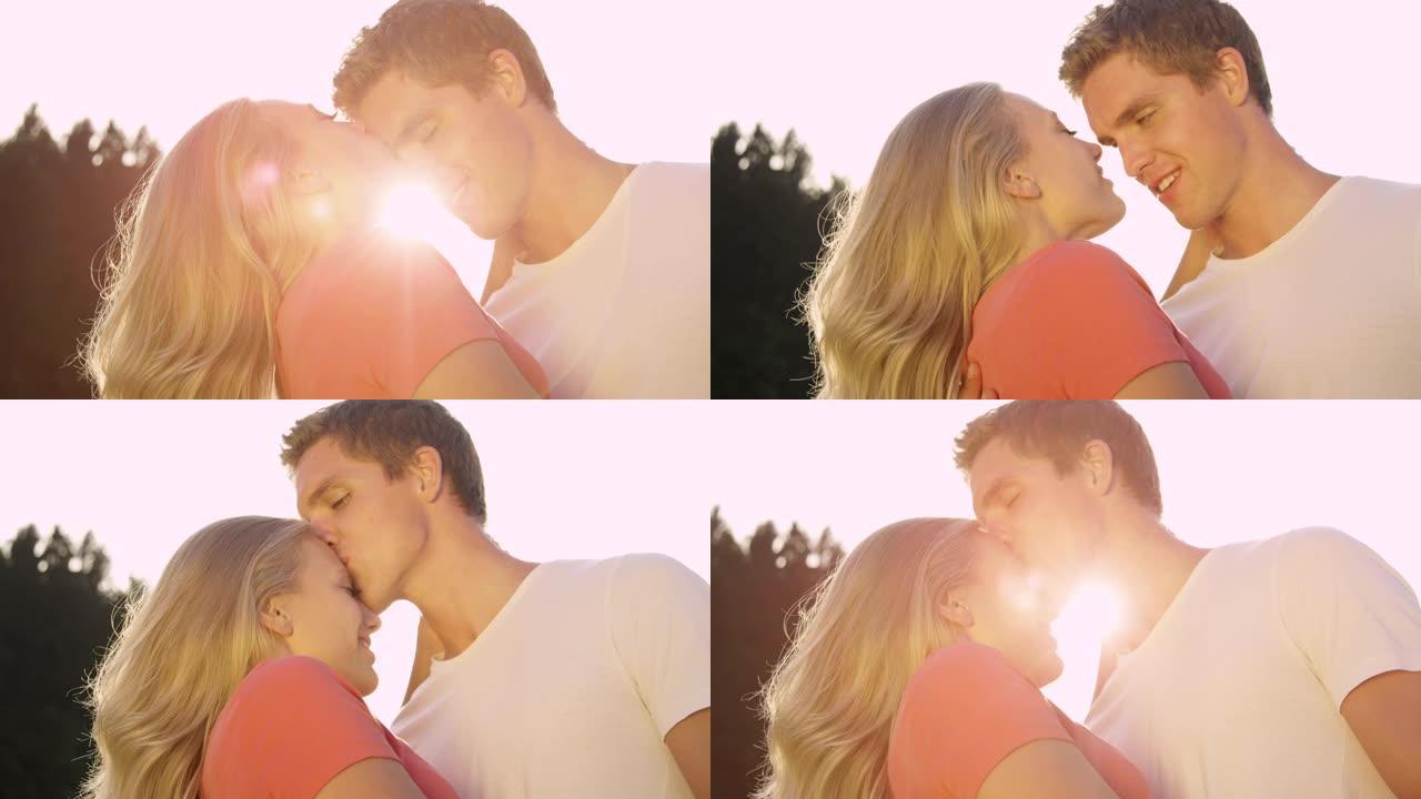 镜头耀斑: 快乐的男人和女人在夏日的额头上互相亲吻。