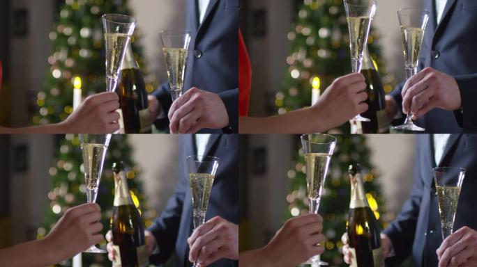 无法辨认的男人和女人在圣诞节触摸香槟长笛