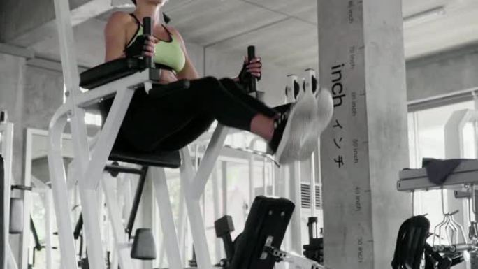 (慢动作) 在健身馆通过健身器锻炼女性体重。