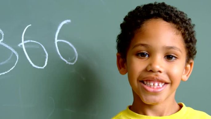4k学校教室里非裔美国男生站在绿色黑板上的前视图