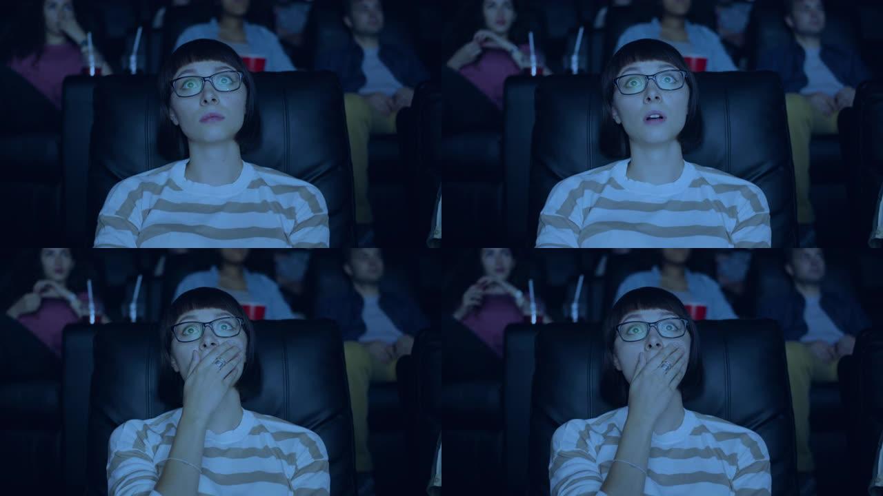 女学生在电影院里看悲伤的戏剧触摸着脸看着屏幕