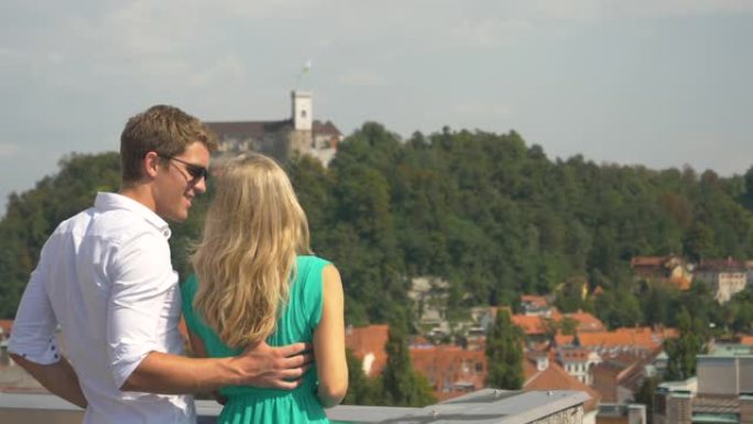 慢动作: 开朗的旅游夫妇从风景秀丽的屋顶上观察卢布尔雅那。