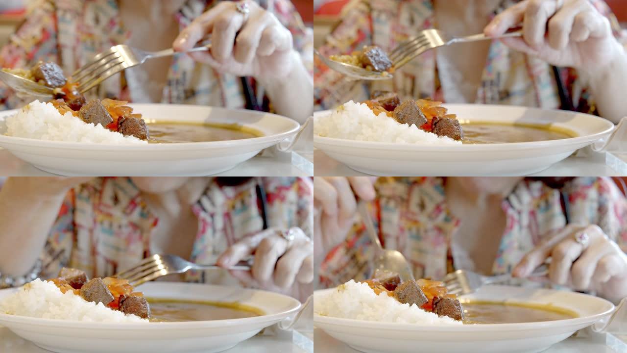 资深亚洲女性吃日本咖喱牛肉。