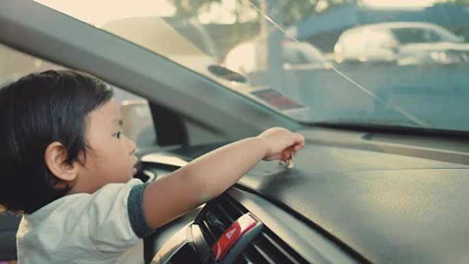 快乐的小男孩坐在车里玩玩具。