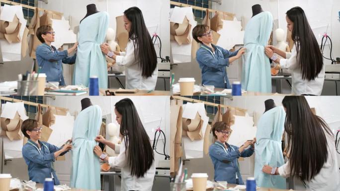 跨种族女性设计师将面料钉在模特上，讨论服装